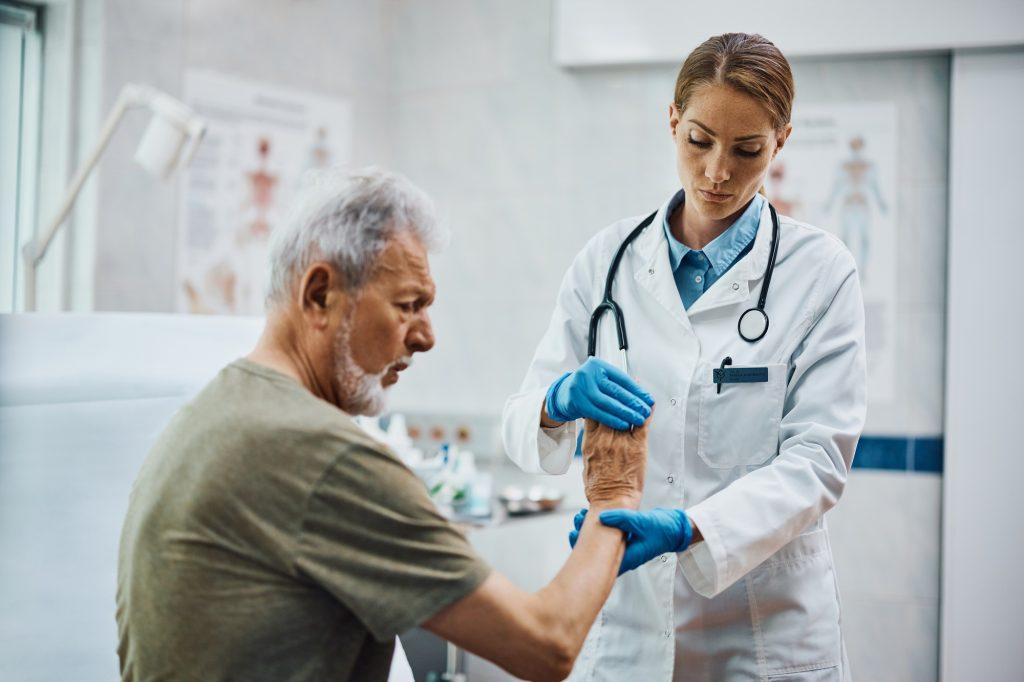 Senior patient having medical examination of at orthopedist office.