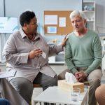 Senior white haired man sharing feelings in mental health support group
