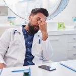 The tired doctor is sitting at the desk