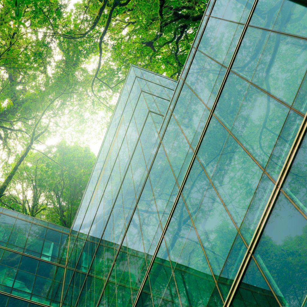 Eco-friendly building in modern city. Sustainable glass office building with trees for reducing CO2.