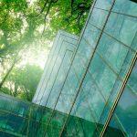 Eco-friendly building in modern city. Sustainable glass office building with trees for reducing CO2.