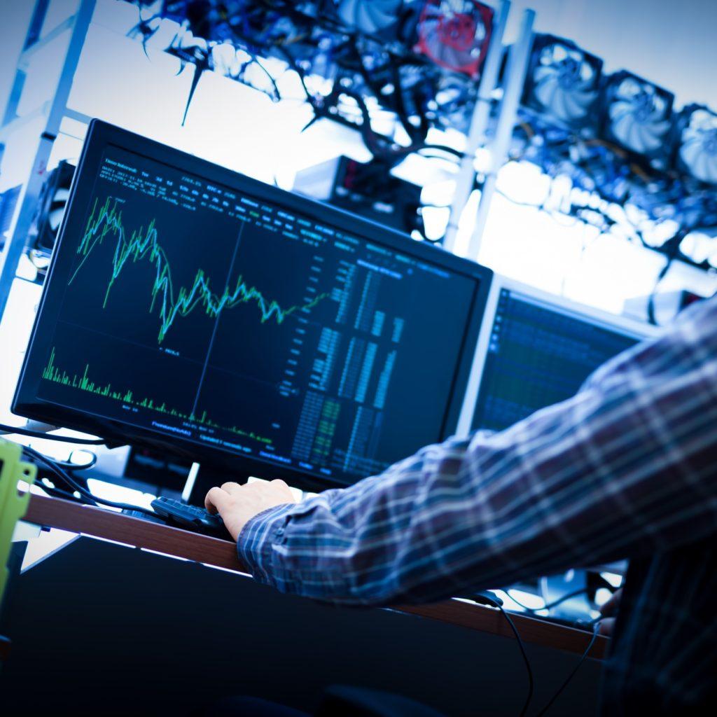 Man working on the computer with bitcoin analyst software.
