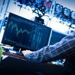 Man working on the computer with bitcoin analyst software.