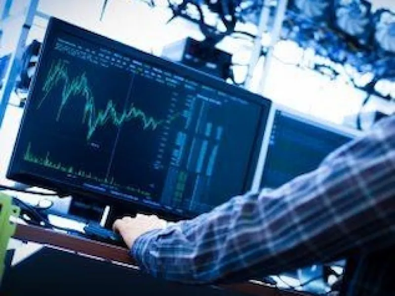 Man sitting in front of his computer, analyzing trends in data.