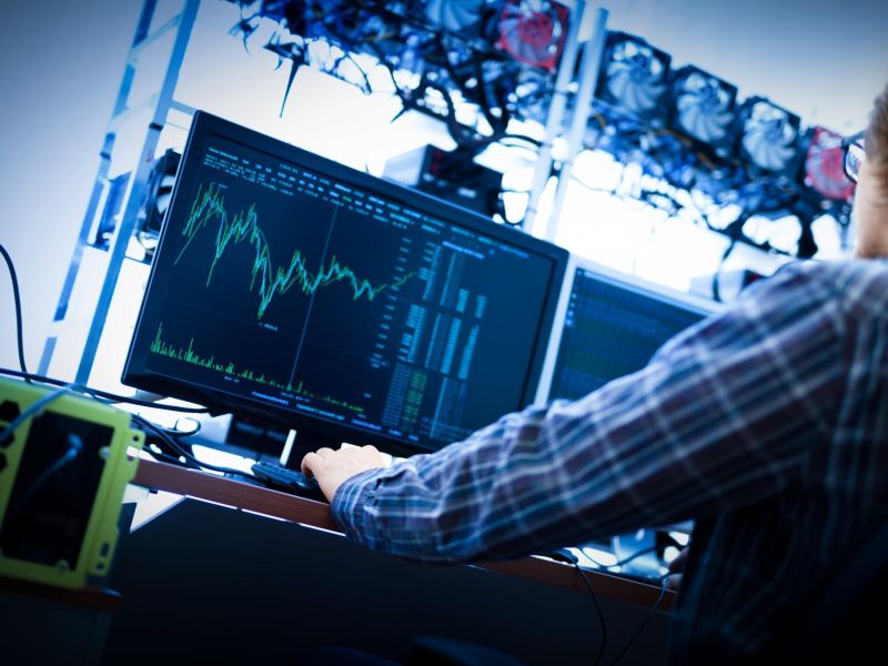 Man working on the computer with bitcoin analyst software.